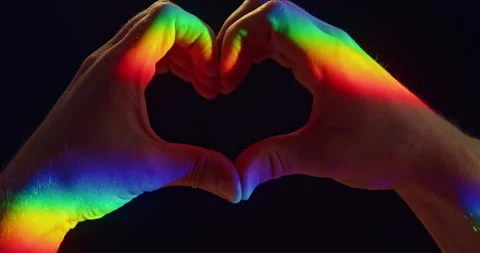 LGBTQ+ Pride Heart Gesture with Two Hands in Rainbow Light on Black Background Stock Footage 341976093