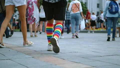 LGBTQ pride parade with walking activist in rainbow knee socks and sneakers. Stock Footage