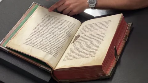 Librarian scrolling through medieval handwritten book in library Stock Footage 264024160