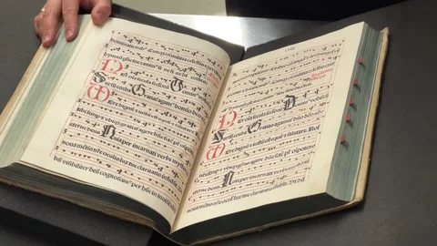 Librarian scrolling through medieval handwritten book in library Stock Footage 264024220