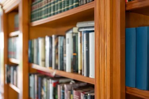 Library full of books of different sizes and colors in the interior of a house. Foto stock