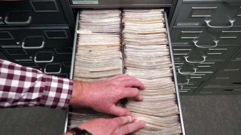 Library man sorting microfiche files inside an archive drawer and close it Stock Footage 237987113