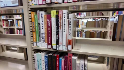 Library shelves showing missing books and empty spaces, symbolizing budget cuts Vidéo 334647026
