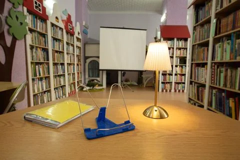 Library study area with warm lighting, colorful bookshelves, and a cozy atm.. 写真素材