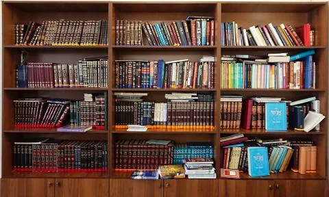 Library in the synagogue. Multi-colored books on the bookshelf in the library Stock Photos