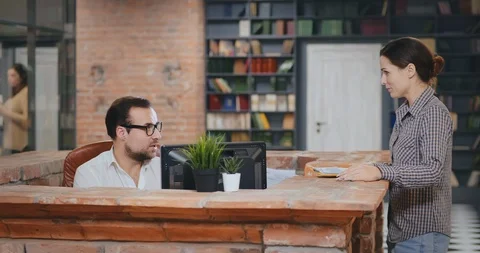 Library worker or salesman talking to woman in bookshop or library Stock Footage 127161758