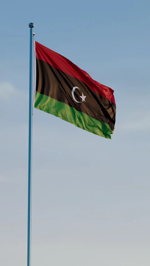 Libya, Tripoli: Cinematic Vertical Waving National Flag Against Blue Sky Видео 321932446