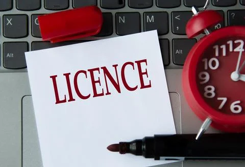 LICENCE on a white sheet against the background of the computer keyboard an.. Stock Photos