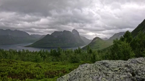 Lichen-covered rock foreground overlooking fjord and village in Senja Norway 스톡 동영상 342059394