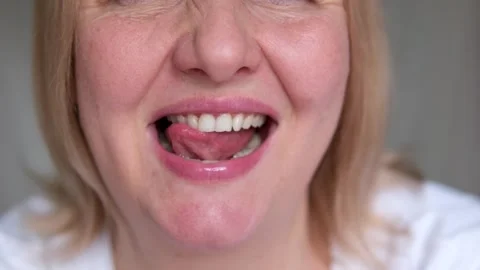 Lick teeth capturing a happy woman licking her lips, showcasing healthy teeth Stock-Footage 286734553