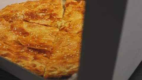 The lid of a cardboard box opens in which a fragrant miracle with a crust i.. 库存影片 275192616