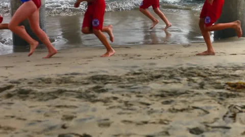 Life guards running on beach Stock Footage 25065579
