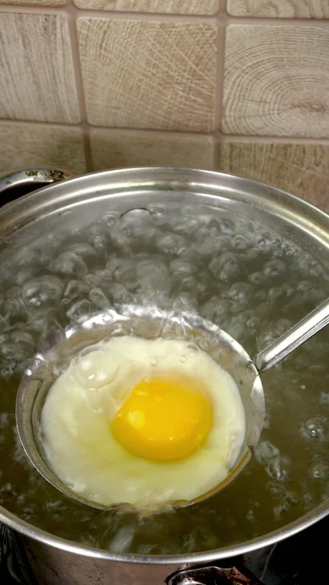 Life hack on how to ideal perfect poached egg in kitchen ladle in boiling water. Stock Footage 232803092