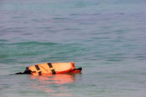The life jacket floats alone on the surface of the sea. Safety on the water. Stock Photos