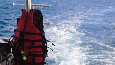 Life jacket on ladders on the rear deck of a yacht moving at sea Stock Footage 235918132
