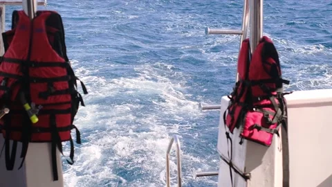 Life jacket on ladders on the rear deck of a yacht moving at sea 스톡 동영상 235918218