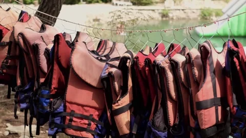 Life jackets hanging against the backdrop of the sea. For sale: lifesaving equip Stock Footage 270085029