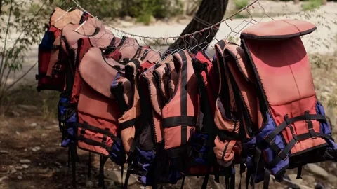 Life jackets hanging against the backdrop of the sea. For sale: lifesaving equip 스톡 동영상 270085033