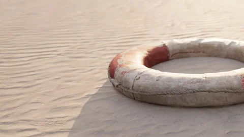 Life ring on sandy beach at sunset with shadows and textures Stock Footage 344819006