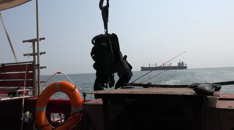 Lifebuoy and scuba diving gear on background of dry-cargo ship on sea horizon Stock Footage