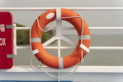 Lifebuoy hanging on a cement wall. Security concept Stock Photos