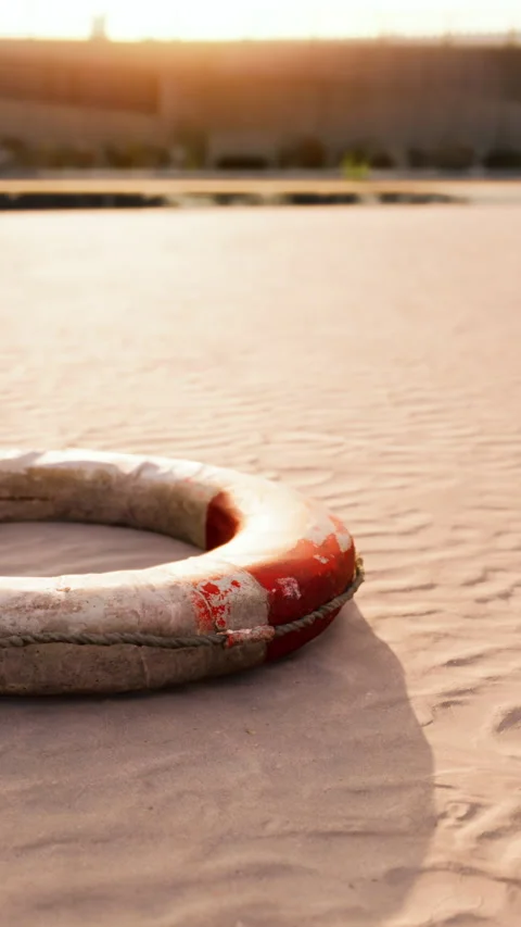 Lifebuoy placed on sandy surface with sun setting in the background Stock Footage 337924790