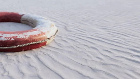 Lifebuoy on sandy beach with textured surface at low tide under cloudy sky Stock Footage 344062949