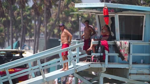 Lifeguard Team on Duty Pointing into the Ocean from a Beach Lookout Station Stock Footage 344998326