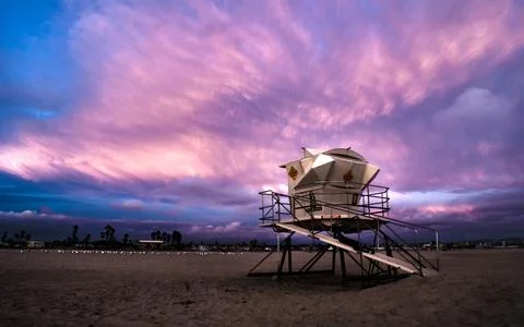 Lifeguard Tower on Beach Under Dramatic Purple Sunset Sky Stock Photos