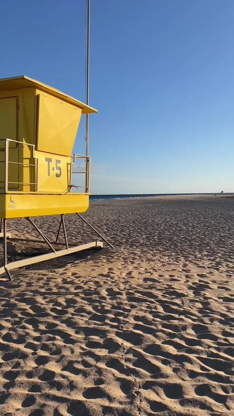 Lifeguard tower pan to Morro Jable lighthouse sandy beach Fuerteventura HD Stock Footage 342027782
