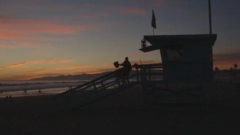 Lifeguard Walking Up To Booth At Beach During Sunset Stock Footage 121288904