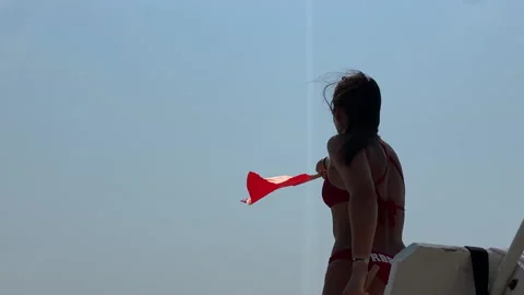 Lifeguard waves red flags during a day at the beach in summer Stock Footage 157848082