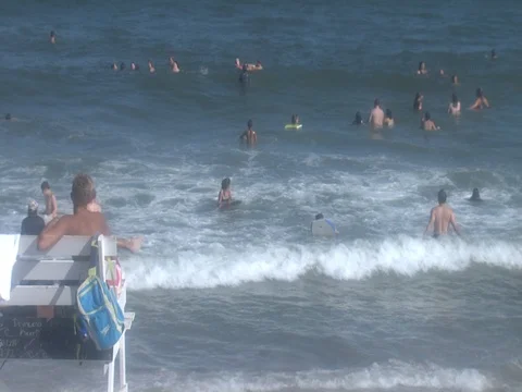 LIFEGUARDS ON BEACH STAND GUARDING OVER SWIMMERS TIMELAPSE Stock Footage 76584382