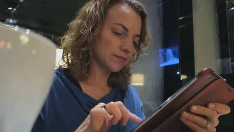 Lifestyle woman using tablet computer touchscreen in cafe.  Stock Footage 74159604