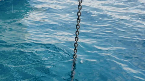 Lifting the anchor chain from the bow of a sailing catamaran Stockbeeldmateriaal 162539943