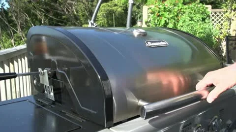 Lifting barbecue lid on spit roast Stock Footage 20804744