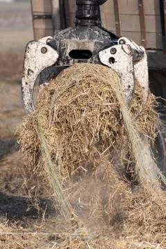 Lifting a bundle of dry straw with forestry grapple Stock Photos