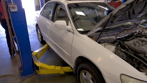 Lifting a car to do an oil change Stock Footage 76973012