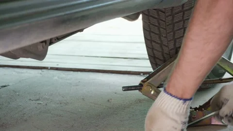 Lifting the car with a jack screw to replace the wheel Stock Footage 130844854