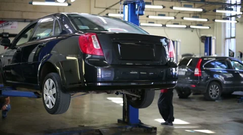 Lifting car on two-post elevator in workshop of Service station Stock Footage 38160740