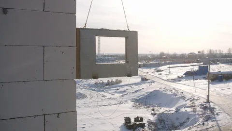 Lifting crane carries thick wall panel to mount in building Stock Footage 124299312