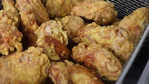 Lifting crispy bone-in fried chicken from deep fryer in a fast food kitchen Stock Footage 340566581