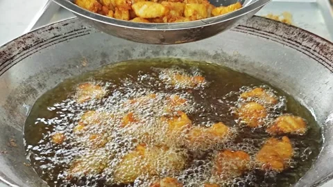Lifting crispy fried fish using a large metal colander over a wok. Vídeo Stock 342739314