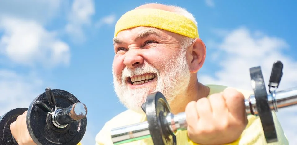 Lifting dumbbells. Elderly man after her workout. Senior sportman lifting Stock Photos