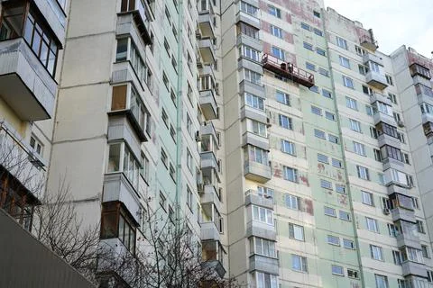 Lifting elevator with workers. They repair and paint the facade. Stock Photos