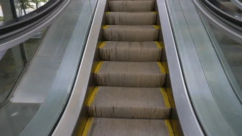 Lifting up on escalator at glass wall on nice day close view Video stock 109607482