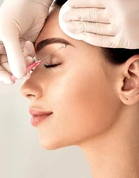 Lifting eyebrow lines using mesothreads. Needle with mesothreads near a femal Stock Photos