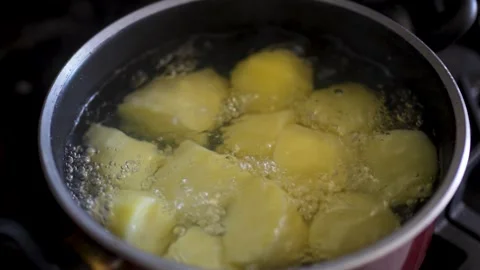 Lifting glass lid from pot with boiling peeled potatoes on stove close up. Vidéo 340036109