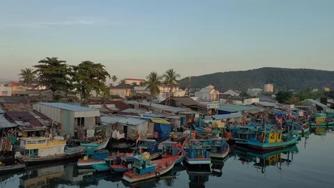 Lifting from harbour full of boats and ships above sea water and town lighed up Video stock 124366053