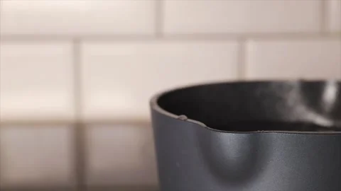 Lifting lid off pan to check boiling water, new pot on induction hob heatin Stock Footage 303080096